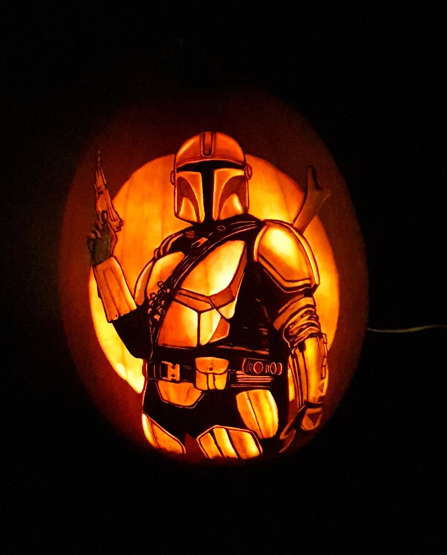 A badass pumpkin carving depicting a fictional character with a helmet and armor, glowing in the dark. A badass pumpkin carving depicting a fictional character with a helmet and armor, glowing in the dark.