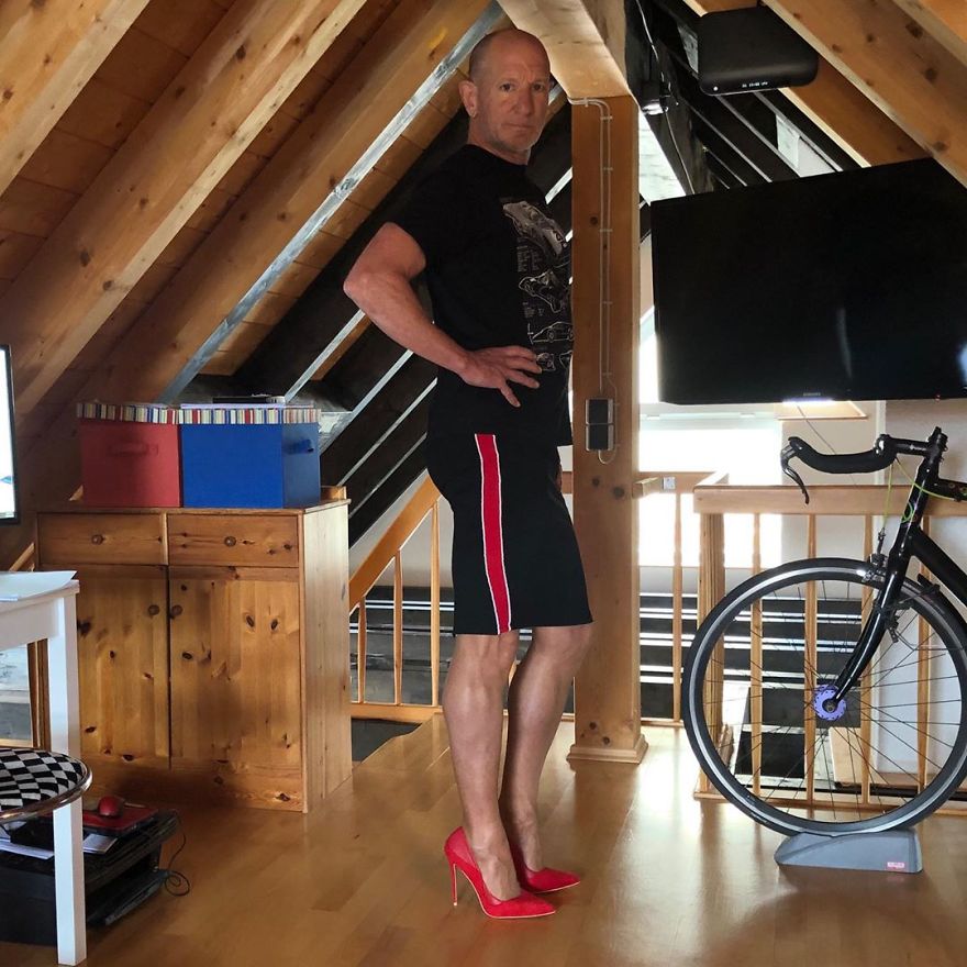 Mark Bryan is wearing a black T-shirt, a black skirt with a red vertical stripe on the side, and red high heels
