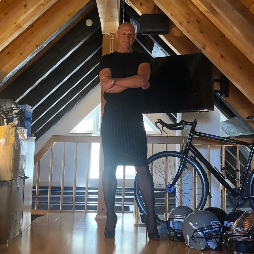 Mark Bryan standing in an attic in a black outfit with a shirt, striped skirt, and high heels