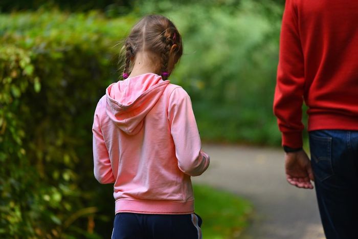 Parent and child walking outdoors on a path with greenery, illustrating what every parent should tell their children.