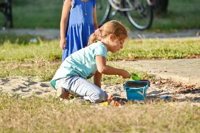 Two children playing in a sandbox outdoors, illustrating what every parent should tell their children about childhood and learning.