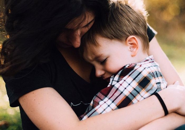 Mother gently hugging her young son outdoors, illustrating parent and child connection and advice every parent should tell children.