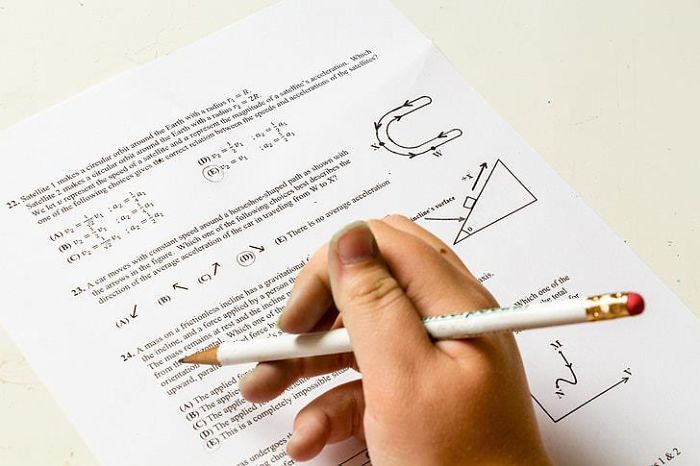 Child holding pencil and solving physics problems on a test paper, highlighting learning every parent should tell their children
