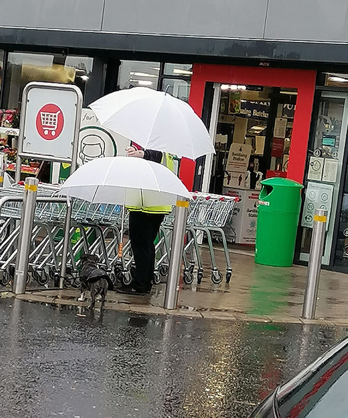 Door Staff Keeping A Customer's Dog Dry While They Shop