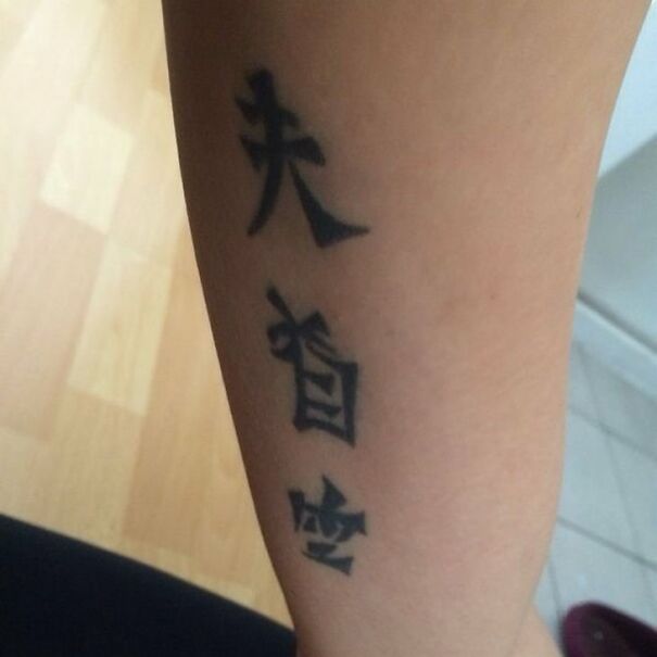 Tattoo with foreign characters on an arm, highlighting amusing translation choices in languages.