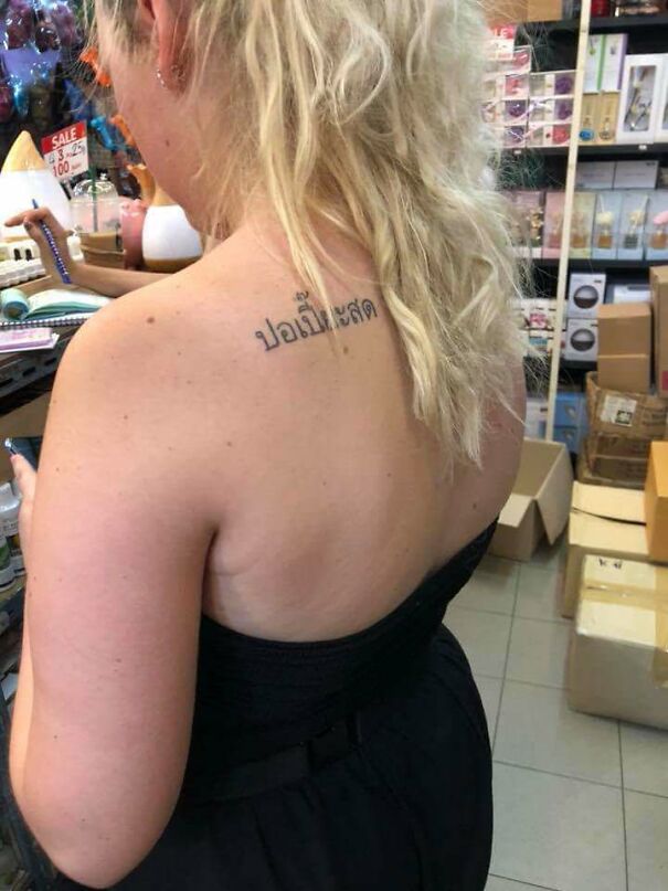 Person with a tattoo in a foreign language on their back, highlighting a humorous tattoo choice.