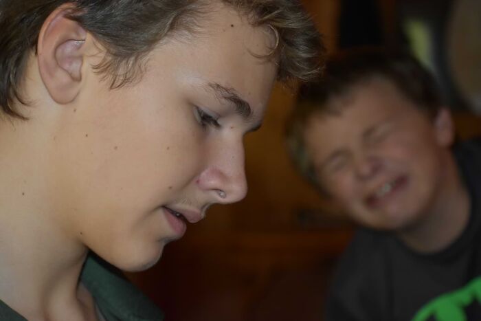 My Brother Was Taking A Picture Of My Brother Reading While Another Brother Stubbed His Toe In The Background