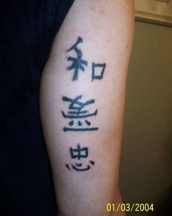 Tattoo with foreign language characters on an arm, illustrating a humorous tattoo choice.
