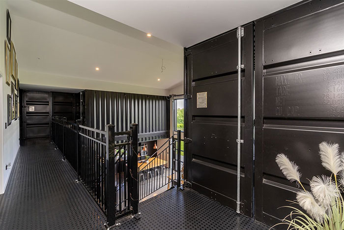 Interior hallway of a stunning house built from shipping containers, featuring modern metal accents.