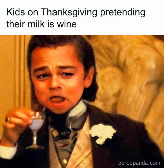 Child acting sophisticated with milk in a fancy goblet during Thanksgiving, humorously mimicking adult behavior.