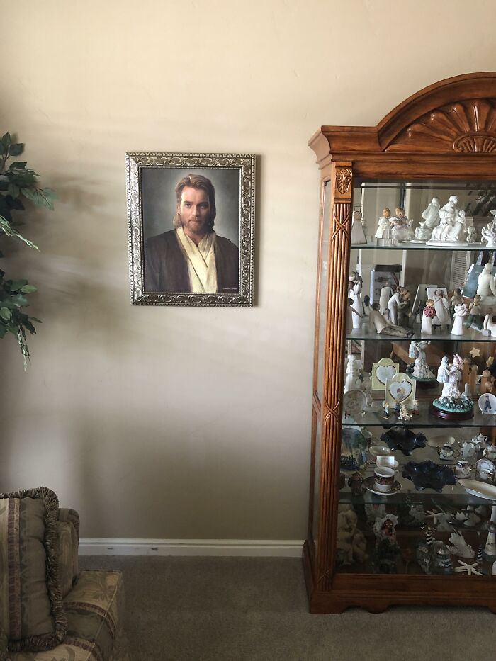 Portrait of Obi-Wan Kenobi in ornate frame on wall, mistaken for Jesus Christ by parents, beside a display cabinet. Portrait of Obi-Wan Kenobi in ornate frame on wall, mistaken for Jesus Christ by parents, beside a display cabinet.