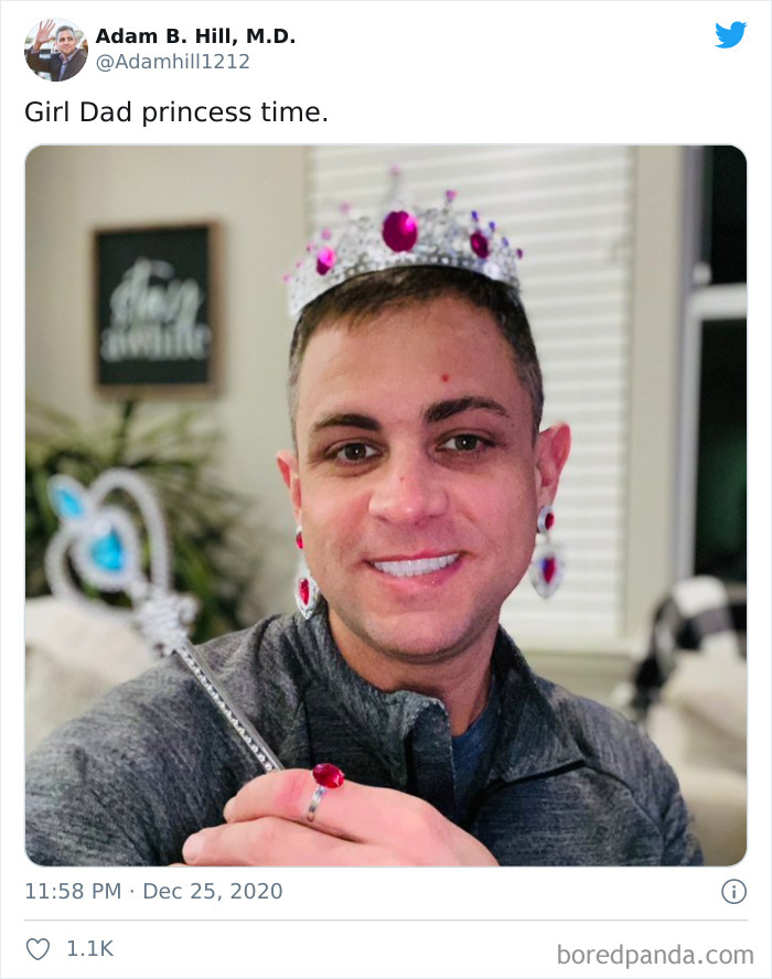 A dad wearing a jeweled crown, earrings, and ring while holding a toy wand after a visit to daughters' beauty salons.