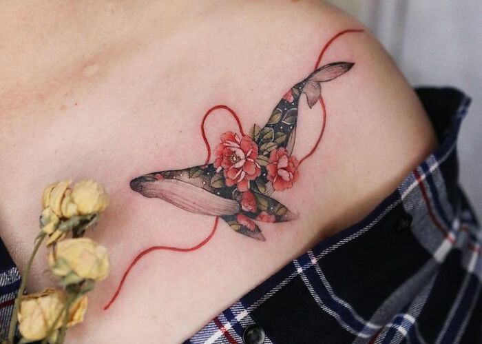 Beautiful body art featuring a floral whale tattoo on a person's shoulder.