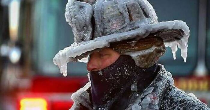 Firefighter Bobby Lehman With His Helmet & Bunker Gear Caked In Ice Tries To Thaw Out After Battling A Stubborn, Wind-Driven House Fire In Nahant, Massachusetts