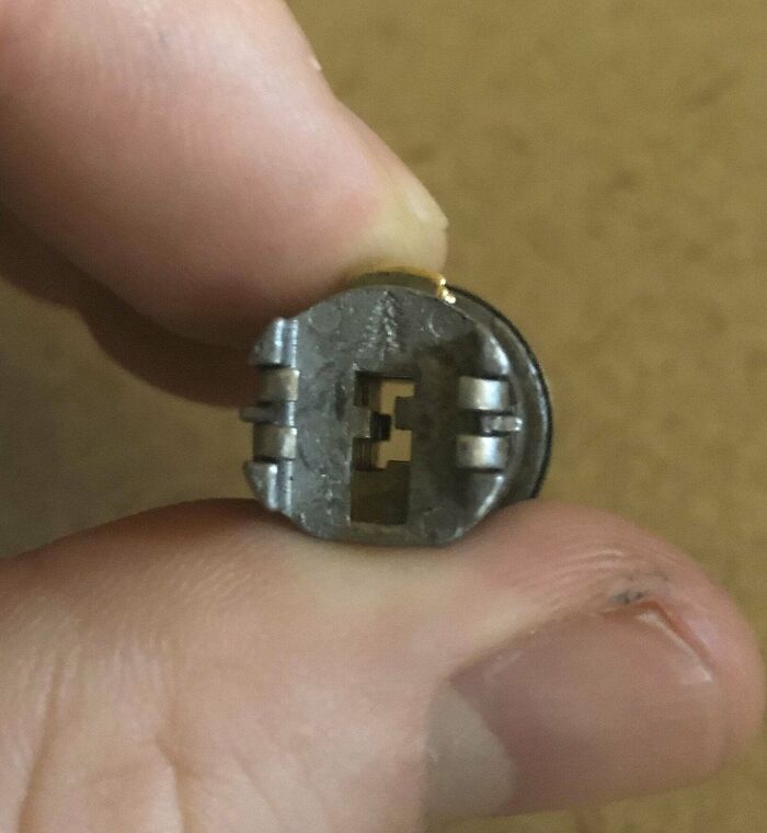 A Little Engraved Pine Tree On The Interior Side Of A Lock That Fell Off A Cabinet At Work