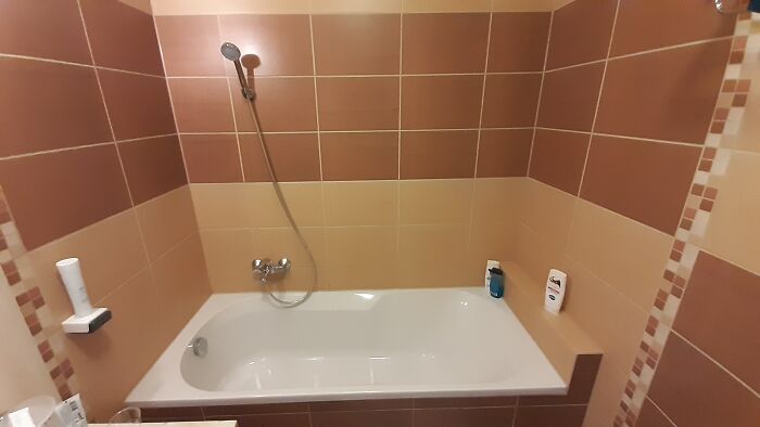 This Non-Adjustable Shower Head Holder That's Set Up To Spray The Water Directly Outward Across The Bathroom