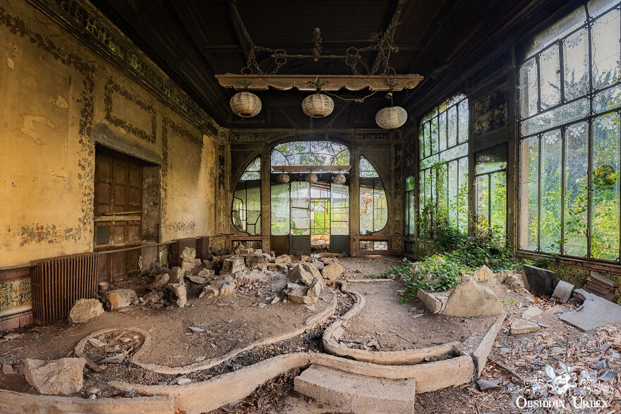 This Indoor Garden Has An Interesting Oriental Theme. There Are The Remains Of A Rockery And A Spiral-Armed Water Feature In The Foreground Of The Photo