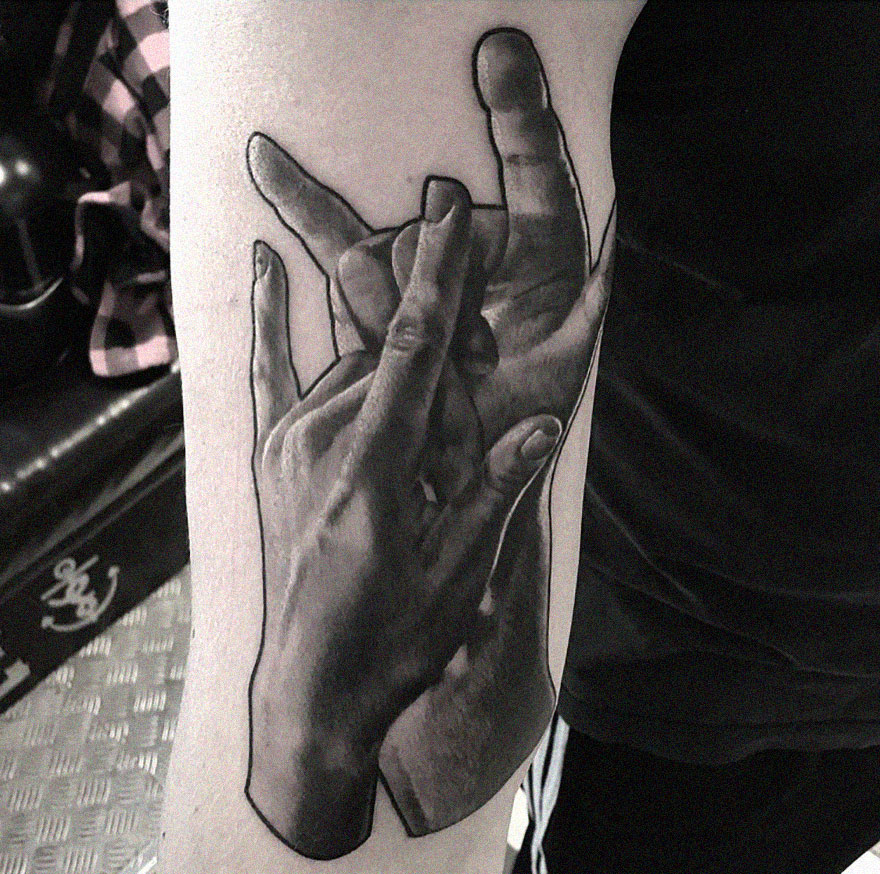 Black and gray realism tattoo of intertwined hands on an arm.