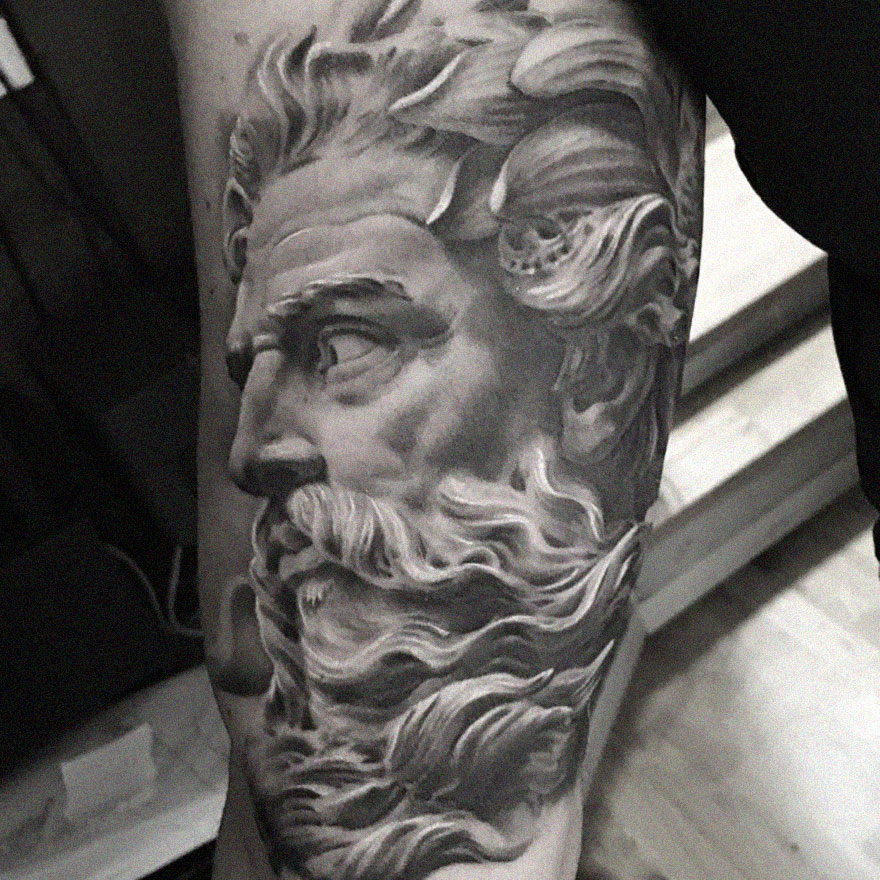 Tattoo of a bearded man's profile on an arm, showcasing black and gray realism by a Swedish artist.