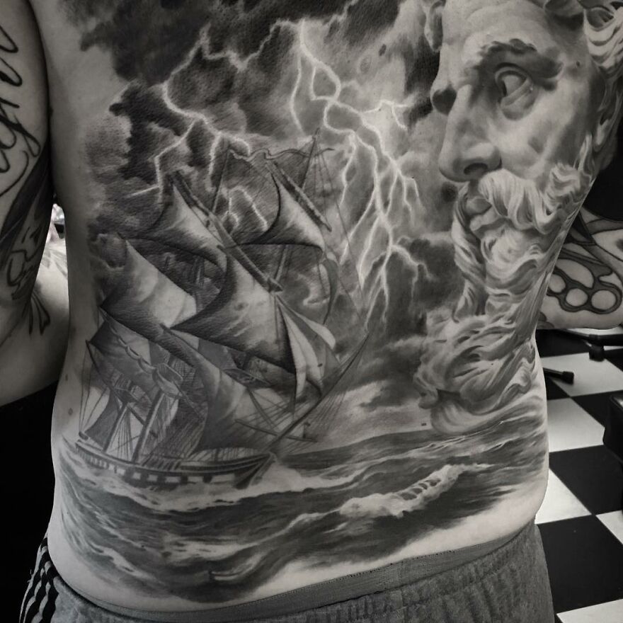 Black and gray realism tattoo of a ship and stormy sea with a bearded figure on a person's back, created by a Swedish artist.
