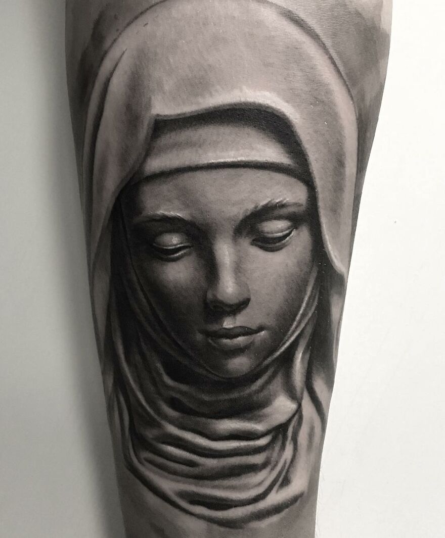 Black and gray realism tattoo of a serene face in a hood, created by a Swedish artist.