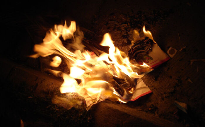 Burning paper with flames at night, illustrating interesting facts people didn’t learn at school concept.