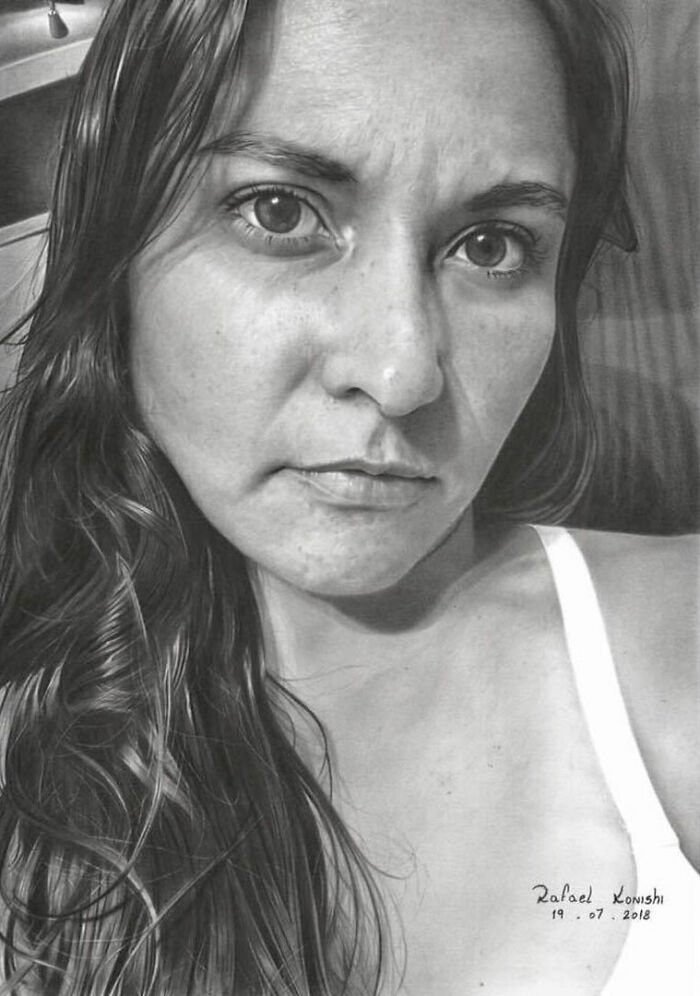 Realistic drawing by Rafael Konishi, depicting a woman's detailed facial features and flowing hair.