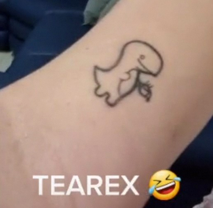 Tattoo of a cartoon dinosaur holding a leaf with text "TEAREX" below, related to dumbest tattoo theme.