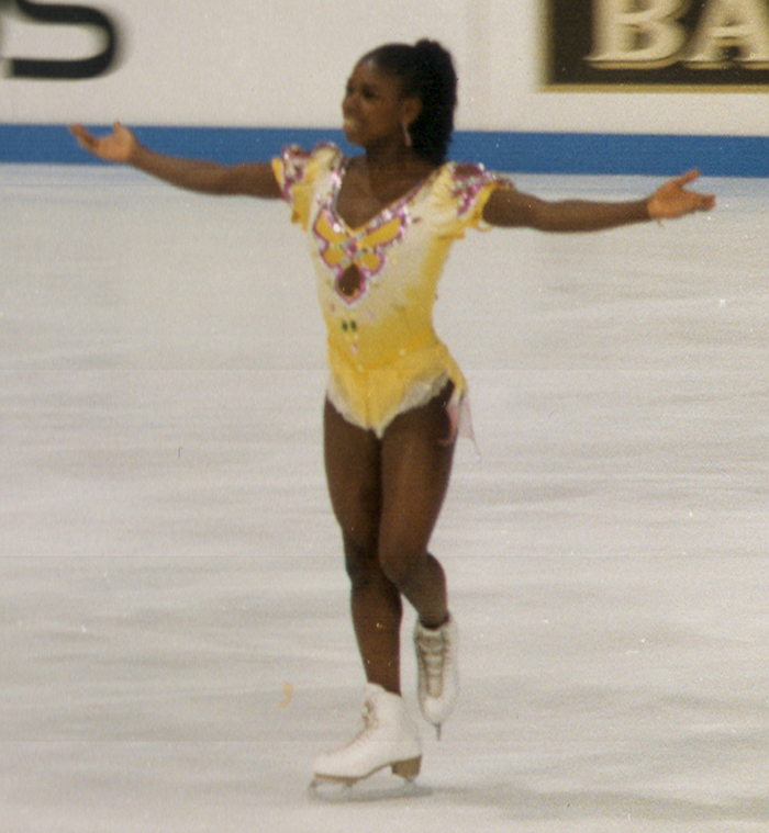 Figure skater in a yellow costume performing on ice, showcasing skills related to interesting facts people didn’t learn at school.