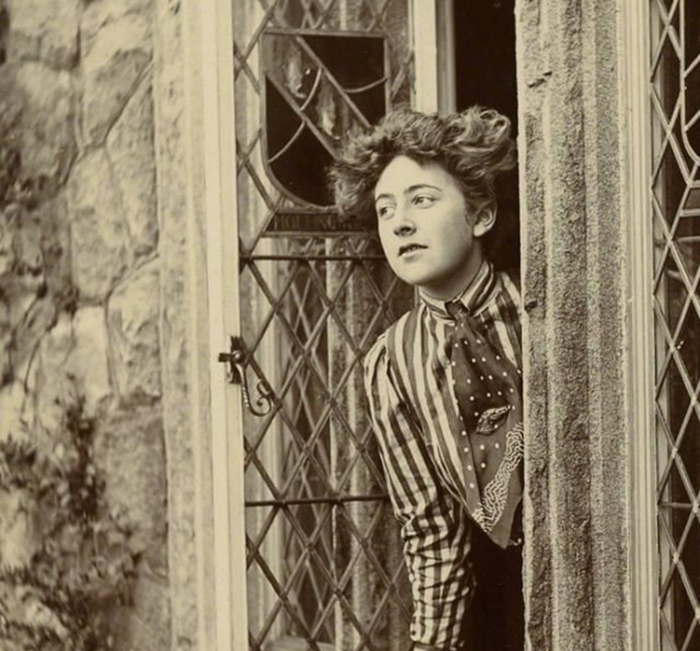 Vintage photo of a woman peeking from behind a door, representing interesting facts people didn’t learn at school.
