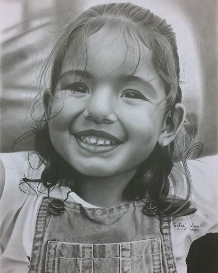 Realistic drawing of a smiling child by artist Rafael Konishi, showcasing detailed pencil artwork.