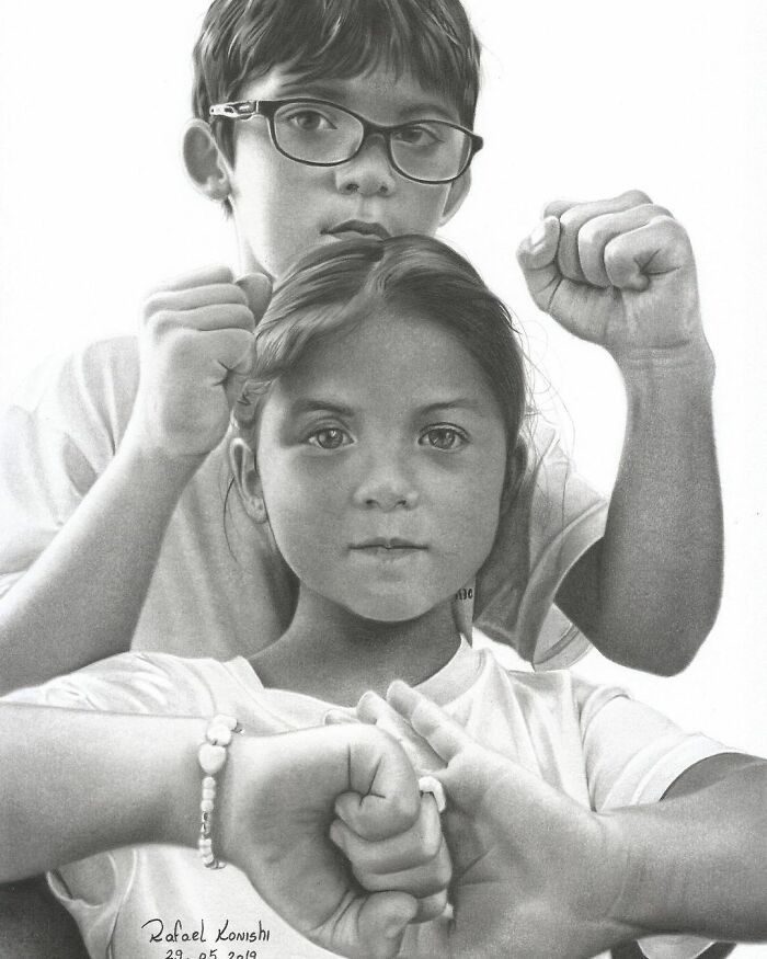Realistic drawing by Rafael Konishi featuring two children with raised fists, showcasing detailed artistry.