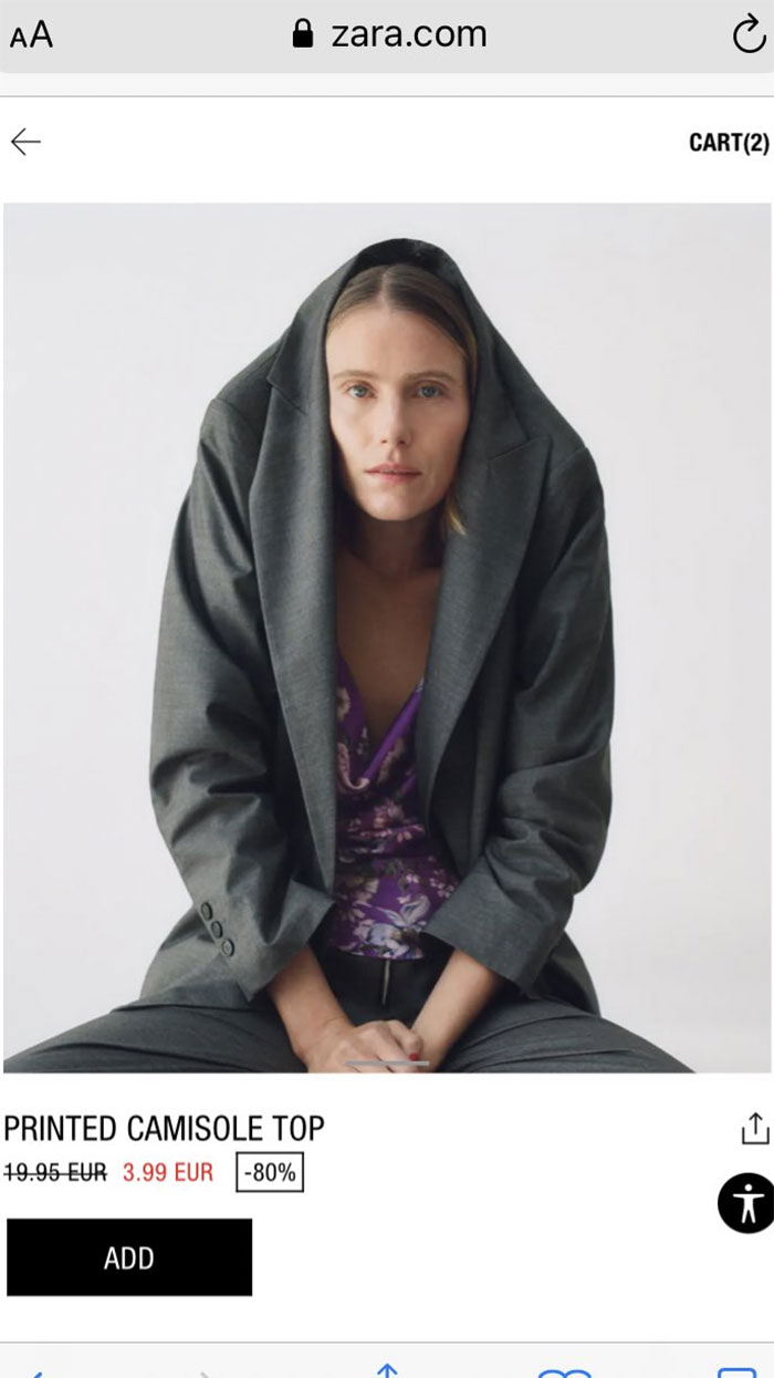 Zara model in unusual pose wearing a gray suit over a floral camisole, showcasing online shopping challenges.