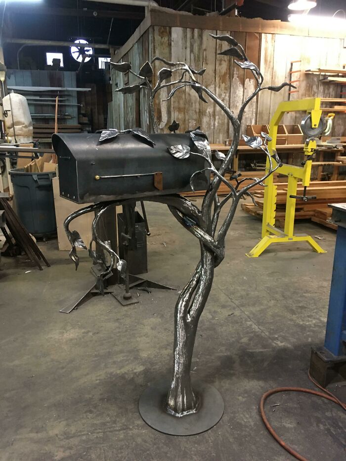 Creative and cool mailbox designed as a metal tree sculpture with leaves in a workshop setting. Creative and cool mailbox designed as a metal tree sculpture with leaves in a workshop setting.