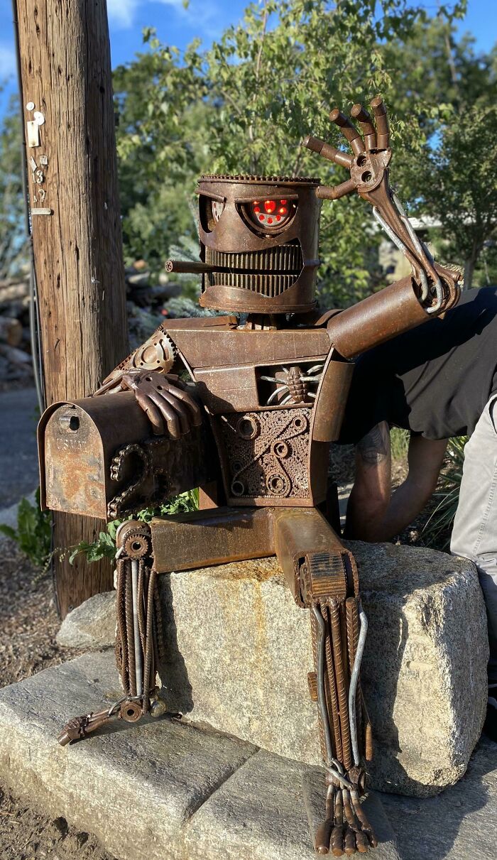 Rusty metal robot sculpture holding a mailbox, representing one of the most creative and cool mailboxes spotted in the wild. Rusty metal robot sculpture holding a mailbox, representing one of the most creative and cool mailboxes spotted in the wild.