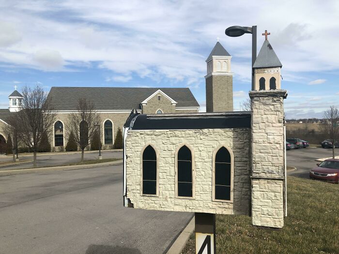 Mailbox designed to look like a miniature church with stone exterior and cross on top, a creative and cool mailbox.