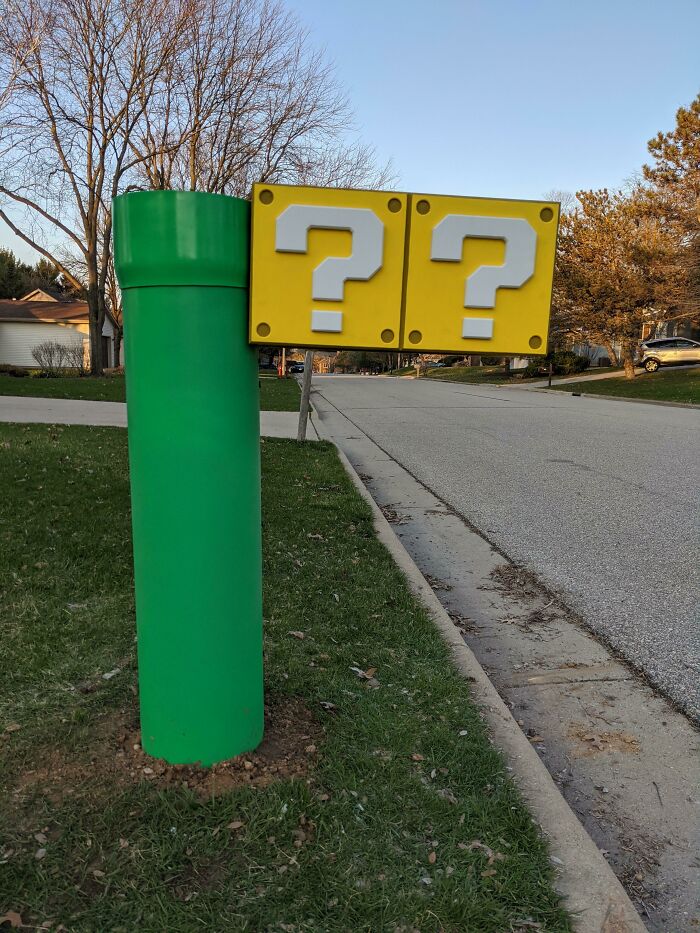 Creative mailbox designed like a green pipe with yellow question mark blocks inspired by video games in a suburban neighborhood.