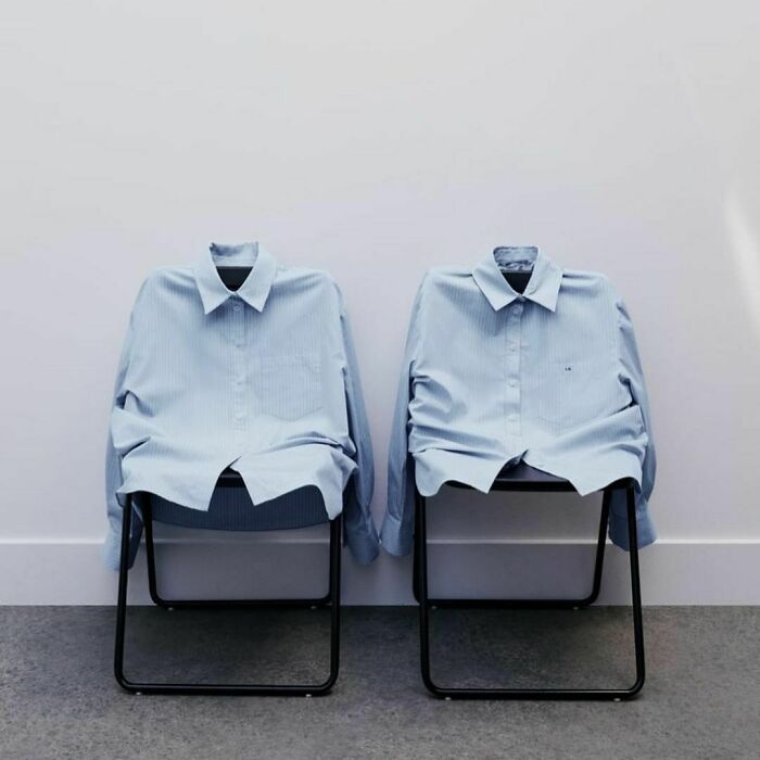 Two blue shirts arranged on chairs, highlighting Zara's unconventional modeling poses online.