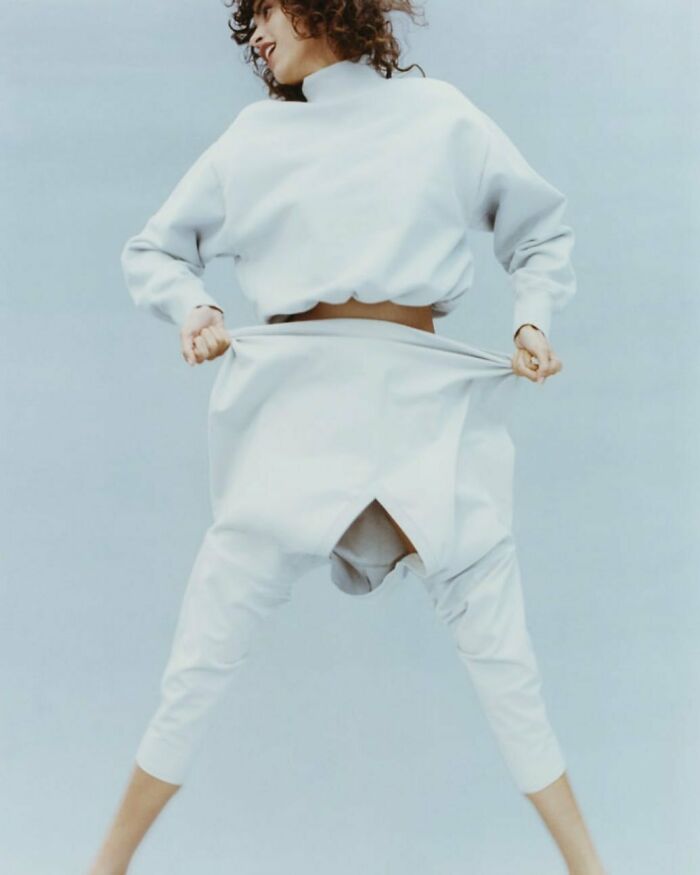 Model in unusual pose wearing white Zara outfit, highlighting shopper concerns over online shopping.