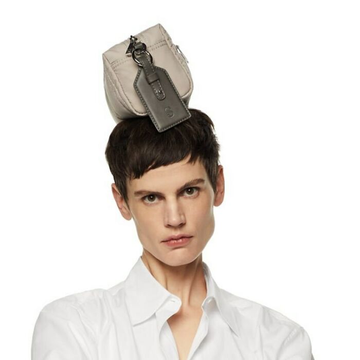 Model posing with a bag on their head in a white shirt, highlighting Zara's unconventional modeling poses.