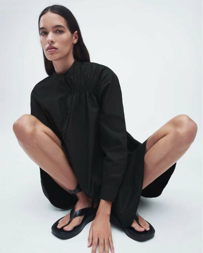 Model in a black dress poses uniquely for Zara online shopping, highlighting unusual modeling styles.
