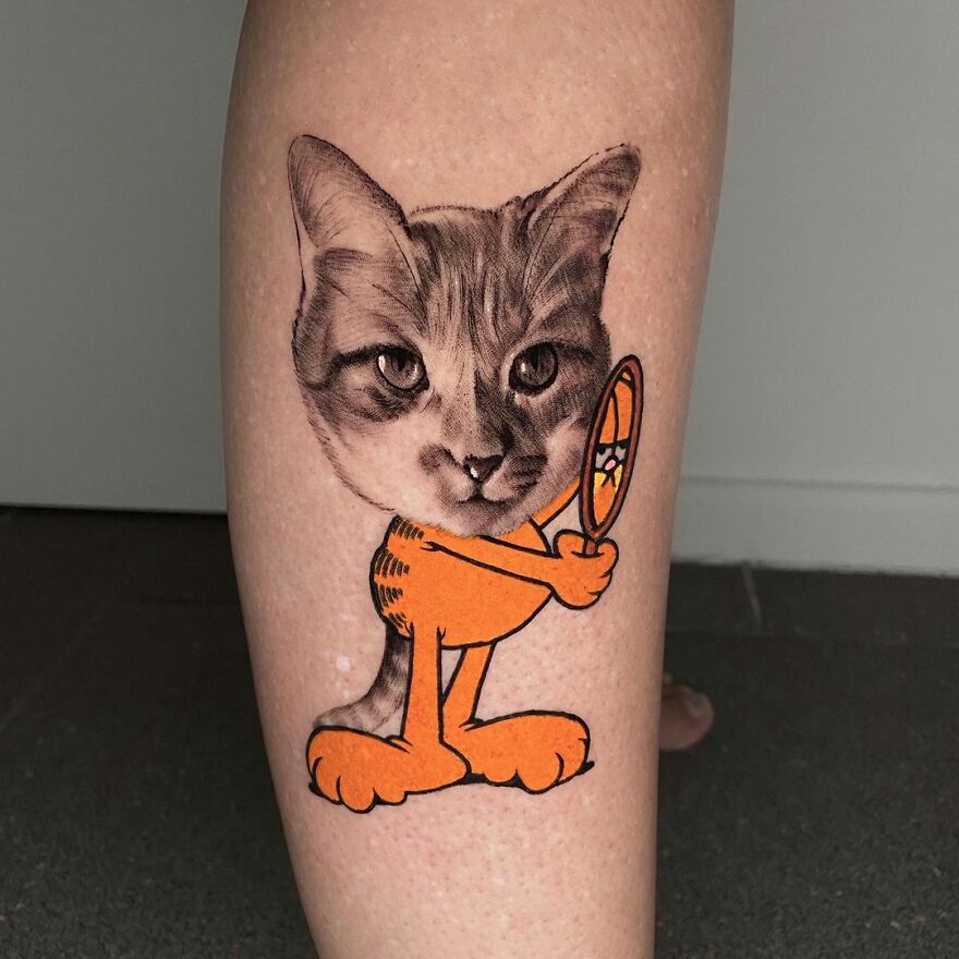 Cat and cartoon-style tattoo by Mat Rule, combining realistic and illustrative art on a person's leg.