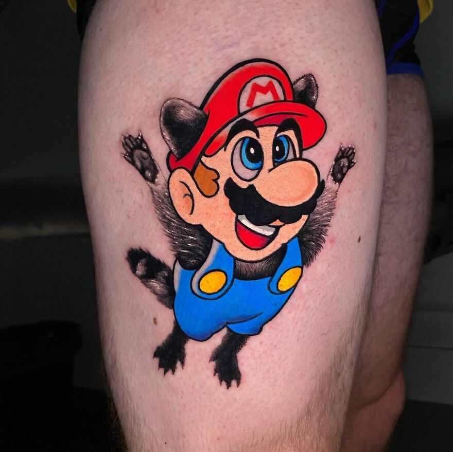 Tattoo of Mario in vibrant color on a person's thigh, showcasing creative styles by Mat Rule.