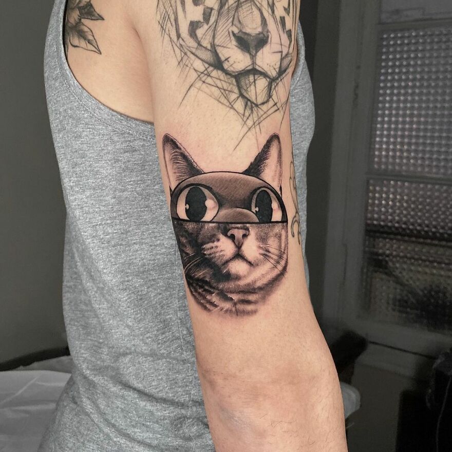 Tattoo combining two styles of a cat and a geometric tiger on an arm.