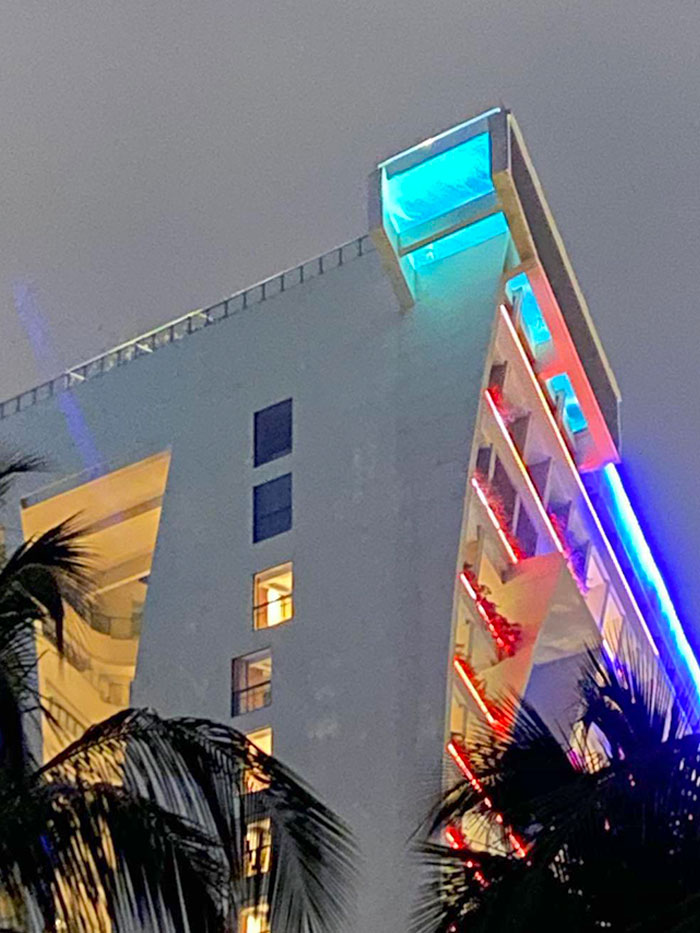 See-Through Corner Of Swimming Pool Extends Out Of The Roof Of A Massive Hotel