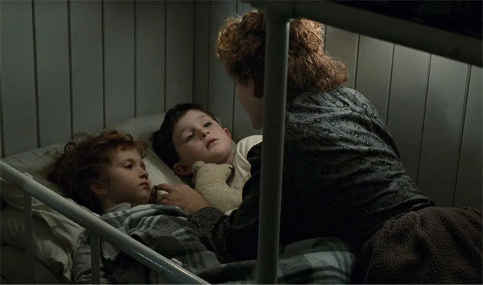 mother telling something to children in bed