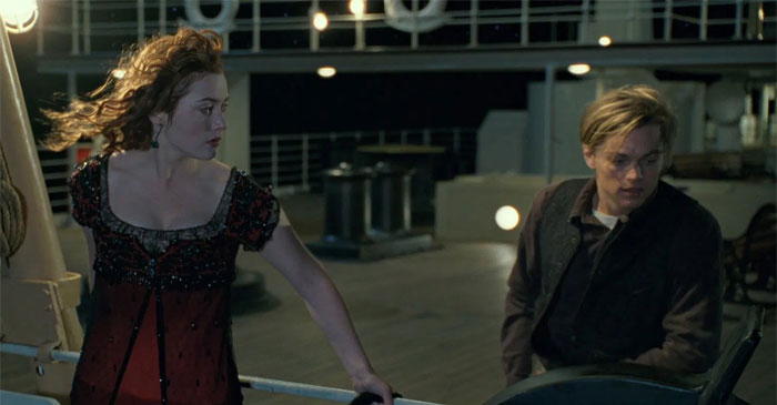Rose standing behind the handrale of the ship and looking at Jack