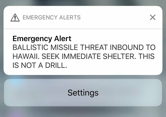 Emergency alert on phone screen warning of ballistic missile threat, illustrating conspiracy theories people believe in.