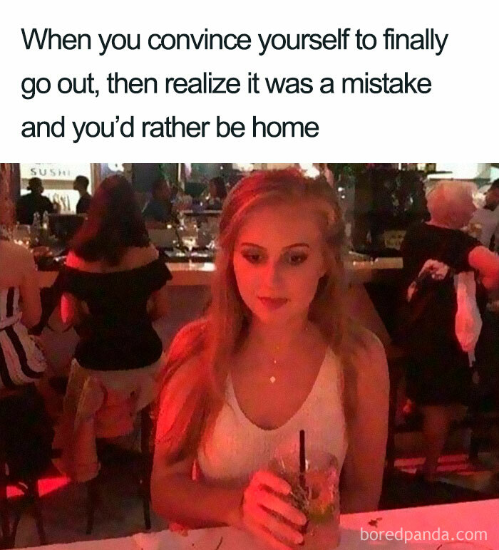 Young woman looking uncomfortable at a bar, capturing the mood of funny introvert memes about social outings.