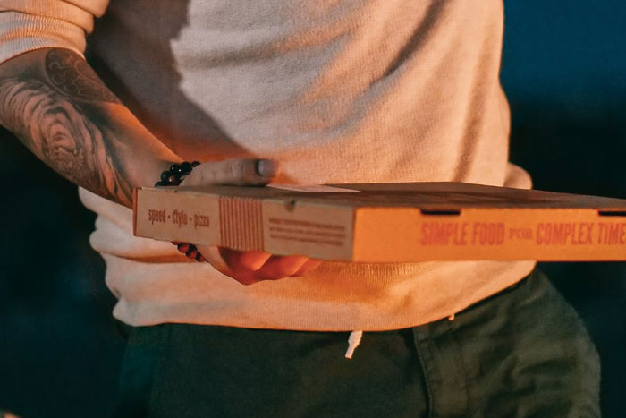 man holding a pizza box